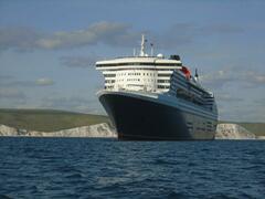 Queen Mary 2 with the Jurassic coast behind