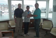 Squib Class Captain and race organizer Alan McDine presenting Cory with his winning trophy and Squib owner Dave McCune.   